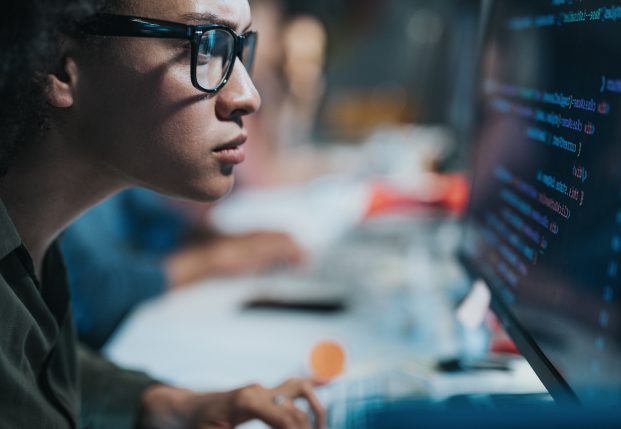 Female coder working on computer screen with code on it. Female coder working on computer screen with code on it.