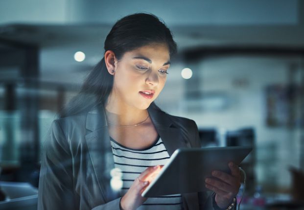 Woman with suit jacket reviewing information on a tablet. Woman with suit jacket reviewing information on a tablet.