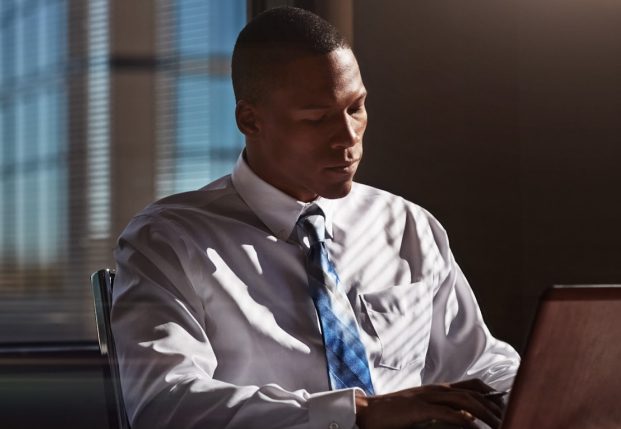 Business man with white shirt and tie sitting at night time in the office and working on computer. Business man with white shirt and tie sitting at night time in the office and working on computer.