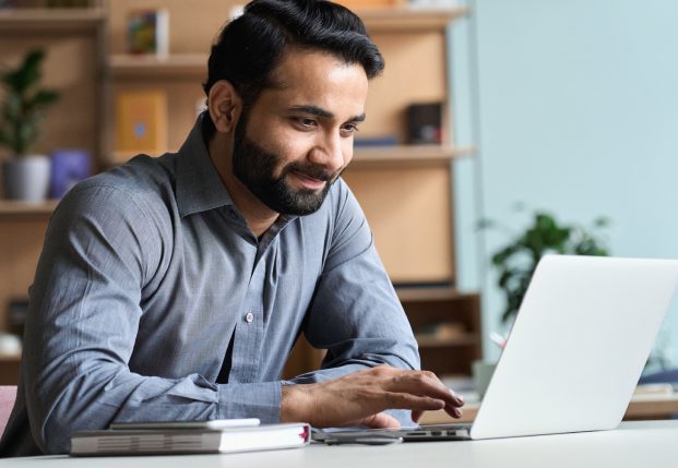 Business Man using computer in office smiling Business Man using computer in office smiling